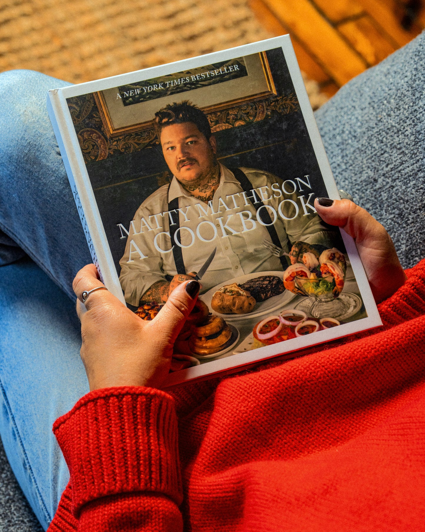 Person holding a cookbook titled 'A Cookbook' by Matty Matheson.
